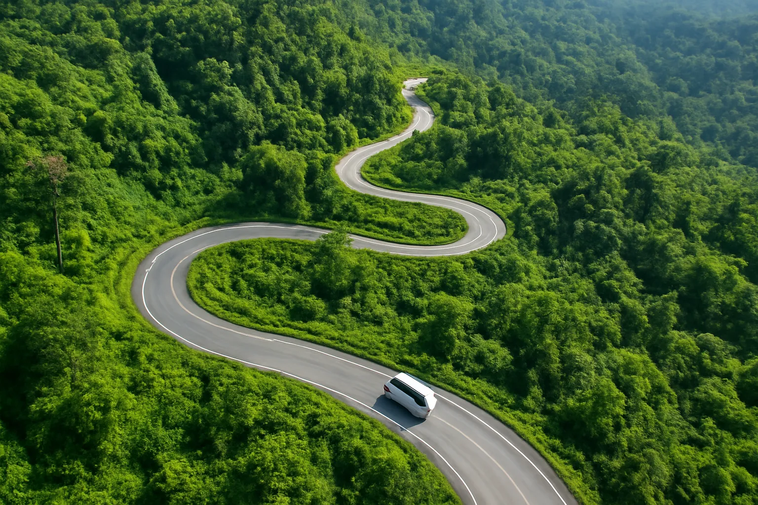 Con đèo quanh co nhìn từ trên cao với một chiếc xe khách nhỏ
